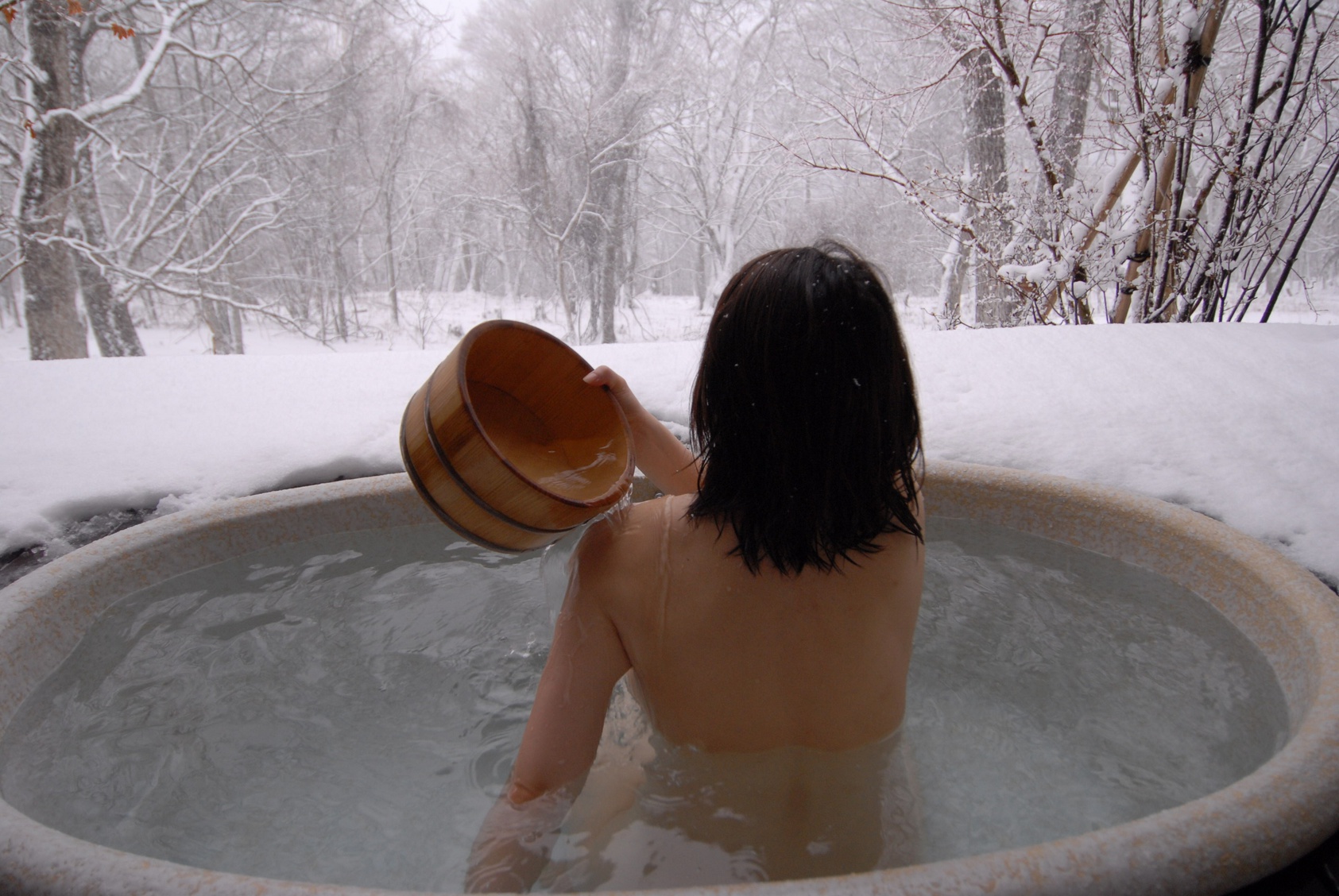 Photo d'une femme dans un onsen d'un ryokan, un incontournable en WHV Japon