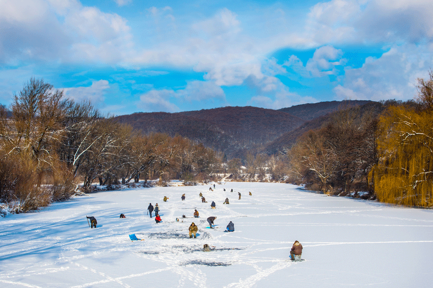 Photo de pecheur sur un lac gele l'hiver au Canada